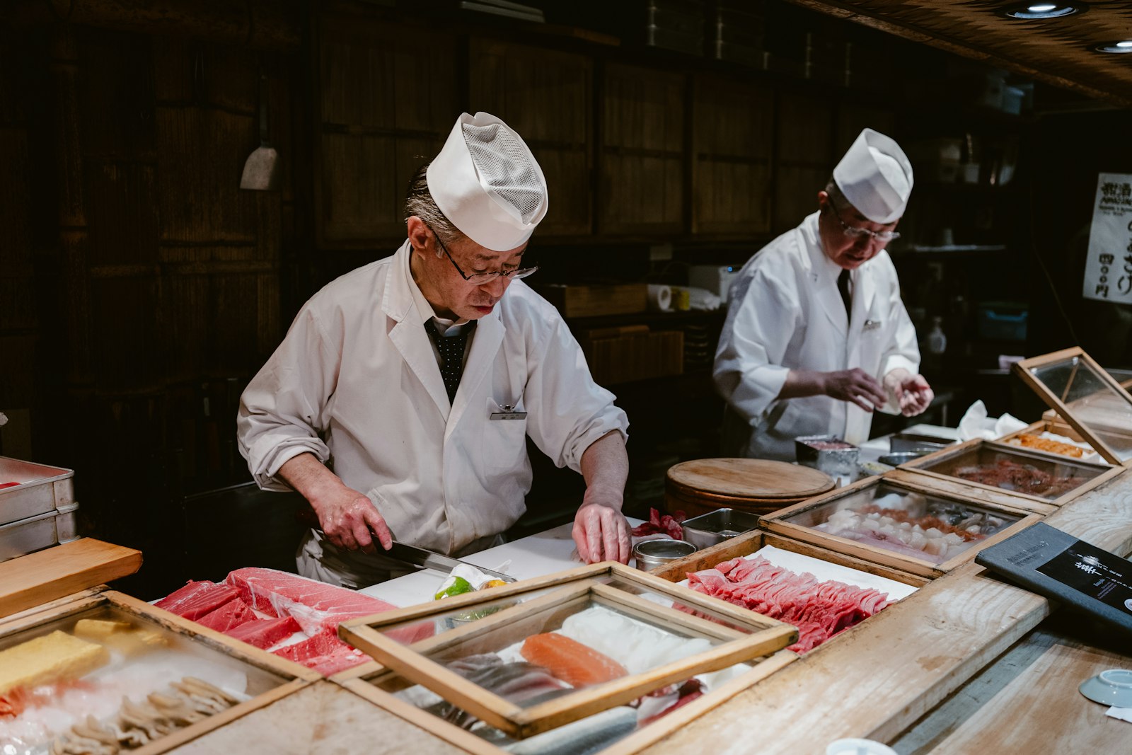 An experienced chef working alongside a cook in a restaurant kitchen, shadowing in practice